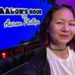 selfie of Christina Aldan in front of a screen that says "Aaron's Hour with Aaron Phillips"